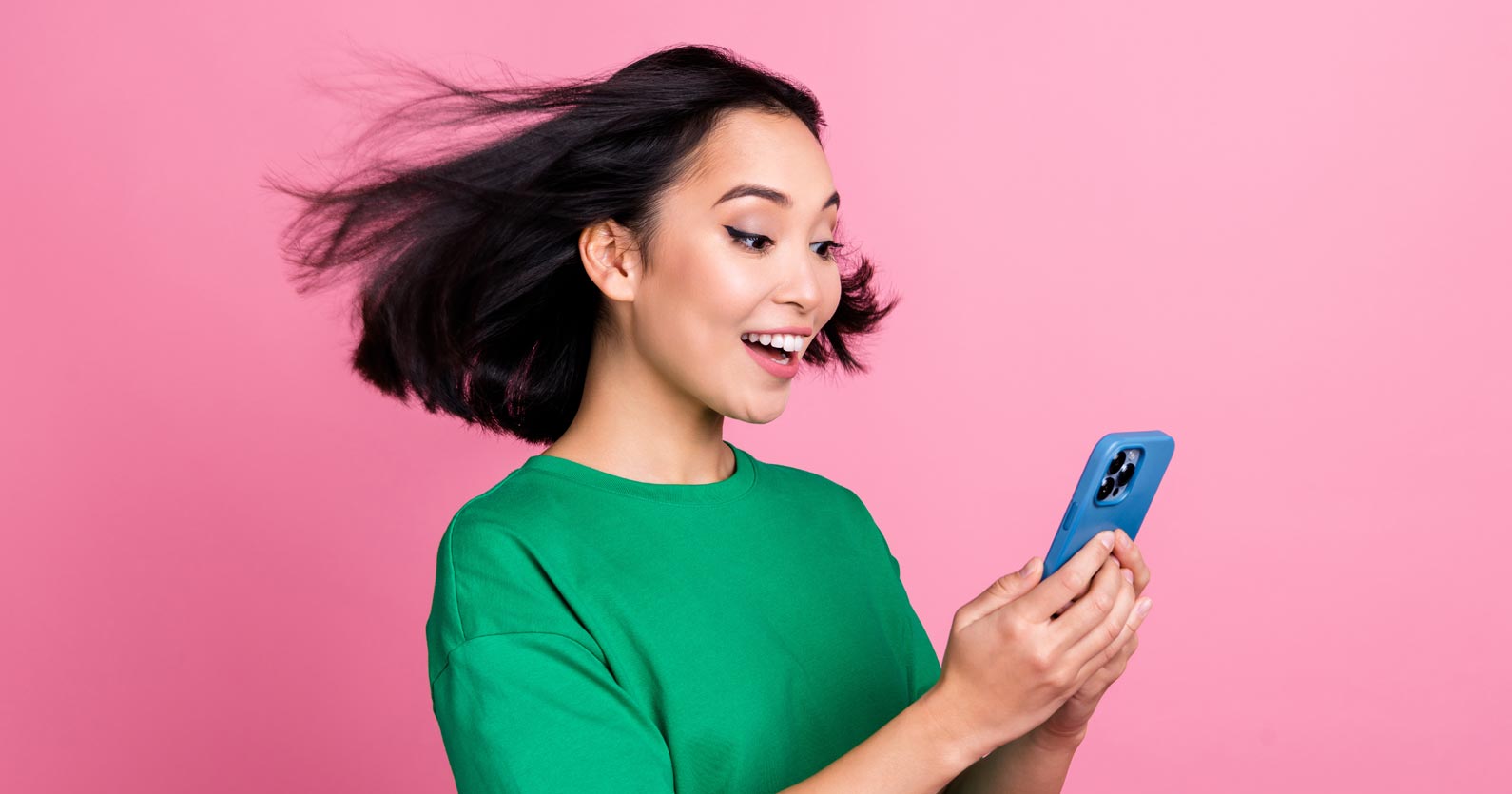 image of woman viewing her phone screen with hair blowing back