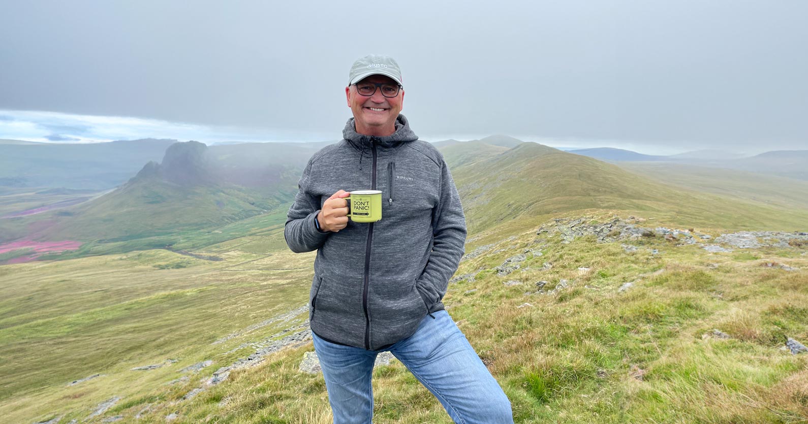 How to Grow a Killer Email List from Scratch 4 image of jonathan christian standing at the top of a hilly landscape holding a cup of coffee